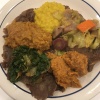 Vegetarian Ethiopian dinner (Atikilit Beyayinetu) A plate of Ethiopian food, with 5 different piles of food on a piece of flatbread