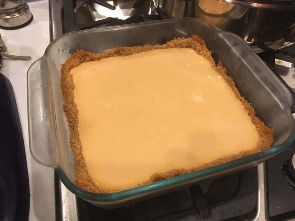 A peachy-colored pie in a square glass pan
